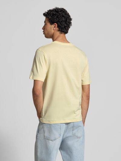 Männermodel trägt T-Shirt mit Statement-Print Modell 'RHYERES' von Jack & Jones aus reine gewachste Baumwolle in Gelb, Regular-Fit, Rückenlänge bei Größe M 67 cm, Ganzkörperansicht Rückansicht.