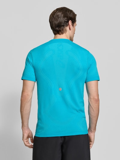 Männermodel trägt Slim Fit RUNNING T-Shirt Modell 'ROAD' von ASICS in Türkis, Rundhalsausschnitt, metallic Label-Print, Rückansicht, Ganzkörperansicht von hinten.