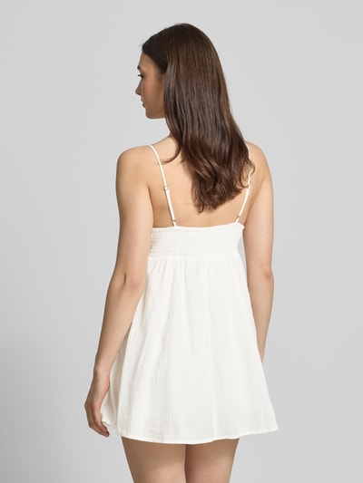Frauenmodel trägt Minikleid aus reiner Baumwolle Modell 'PANOLA' von Only, Optik: Unifarben, Mini-Länge, verstellbare Spaghettiträger, Ganzkörperansicht Rückansicht.