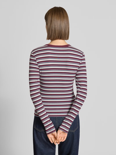 Frauenmodel trägt Regular Fit Langarmshirt aus Baumwoll-Mix Modell 'VAL' von ONLY mit Streifen in Lila, Weiß und Rot, Damen Langarmshirt, Ganzkörperansicht Rückansicht.
