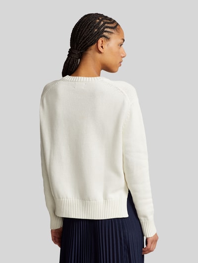 Modelka kobieca ma na sobie Regular Fit Strickpullover aus reiner Baumwolle od Polo Ralph Lauren, kremowy, dzianina, gładki, logo, długi rękaw, prążkowane wykończenia, rozcięcia po bokach, widok całej sylwetki z tyłu.