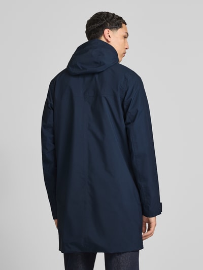 Mężczyznamodel nosi Regular Fit Regenmantel mit Logo-Detail Modell 'Brussel' von Helly Hansen, granatowy, kaptur, wpuszczane kieszenie, stójka, długość tyłu w rozmiarze M: 90 cm, szerokość ramion w rozmiarze M: 42 cm, szerokość klatki piersiowej w rozmiarze M: 51 cm, długość rękawów w rozmiarze M: 68 cm, widok całej sylwetki z tyłu