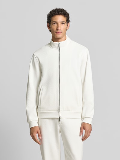 Männermodel trägt Sweatjacke mit Stehkragen und Zweiwege-Reißverschluss von Emporio Armani, Baumwoll-Mix mit Lyocell, Regular Fit, weiß, glatte Textur, Eingrifftaschen, Ganzkörperansicht von vorne.