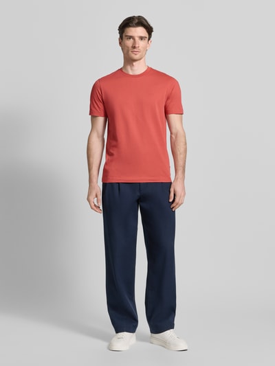 Männermodel trägt Regular Fit T-Shirt aus reiner Baumwolle Modell 'Thompson 01' von BOSS in Rot, unifarben, Ganzkörperansicht von vorne.