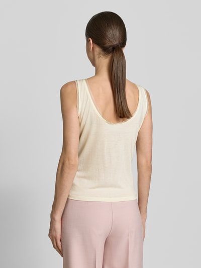 Modelka nosi top Tanktop mit Rundhalsausschnitt und abgerundetem Saum od Jake*s Casual, krój loose fit, okrągły dekolt, lekko zaokrąglony dół, ozdobne obszycie, długość tyłu w rozmiarze S: 36 cm, jasny kremowy kolor, gładka faktura, widoczne spodnie w jasno różowym kolorze, widok całej sylwetki z tyłu.