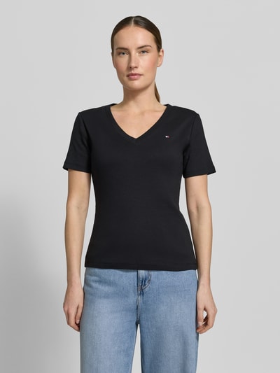 Frauenmodel trägt Slim Fit T-Shirt aus reiner Baumwolle von Tommy Hilfiger, Optik: Unifarben, Logo-Stitching, Jersey, V-Ausschnitt, Ärmelform: Kurzarm, Materialverarbeitung: Reine Baumwolle, Ganzkörperansicht von vorne.