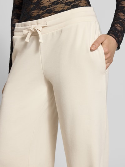 Kobiece model prezentuje Wide Fit Sweatpants mit Viskose-Anteil od REVIEW, mieszanka bawełny i wiskozy, krój wide fit, elastyczny pas z tunelem, długość wewnętrzna nogawki w rozmiarze S: 89 cm, zbliżenie na górną część spodni