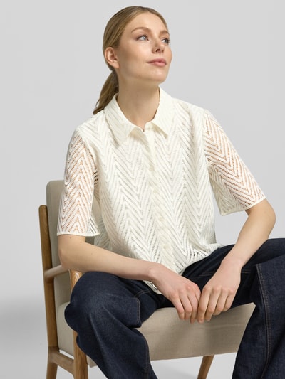 Frauenmodel trägt Regular Fit Hemdbluse in Spitzen-Optik von comma, semitransparent mit Hemdblusenkragen und Halbarm, Nahaufnahme Oberkörper.
