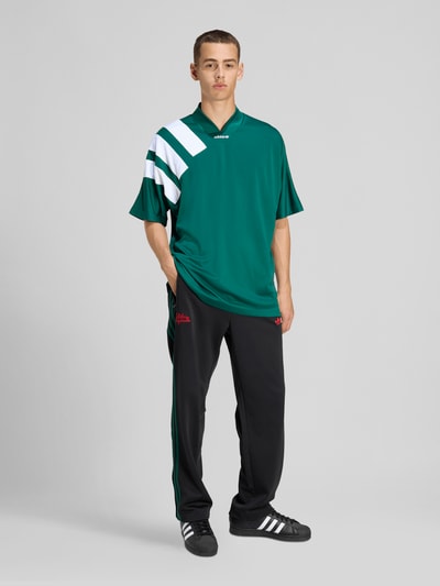 Mannelijk model draagt Regular Fit Sweatpants met katoen van adidas Originals, look: effen, regular fit pasvorm, gestikt logo, galonstrepen, boord: elastisch, materiaalverwerking: sweat, Ganzkörperansicht van voren.