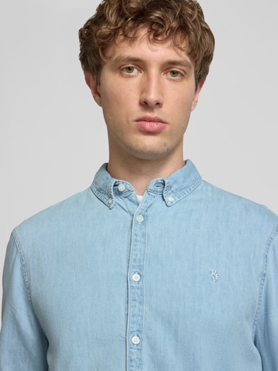 Männermodel trägt Regular Fit Freizeithemd in Denim-Optik von REVIEW, hellblaue Baumwolle, Button-Down-Kragen, Logo-Stitching, Nahaufnahme Oberkörper.