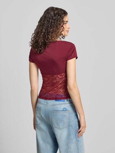 Frauenmodel trägt Damen T-Shirt mit V-Ausschnitt und Spitze von Gina Tricot, Material-Mix mit Stretch-Anteil, Slim Fit, Rückenlänge 51 cm, Ganzkörperansicht Rückansicht.