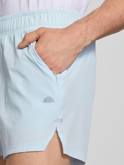 Männermodel trägt Shorts mit elastischem Bund Modell 'ERUDITO' von Ellesse in Hellblau, Material-Mix mit Stretch-Anteil, Nahaufnahme Oberschenkel. Regular Fit, Bundweite 39 cm, Innenbeinlänge 12 cm.