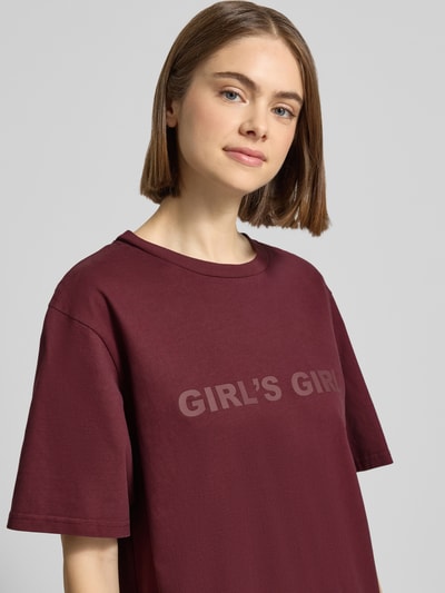 Frauenmodel trägt Oversized T-Shirt mit Statement-Print von OH APRIL in Dunkelrot aus Reine Baumwolle, Oversized-Fit, Gerippter Rundhalsausschnitt, Rückenlänge bei Größe S: 70 cm, Nahaufnahme Oberkörper.