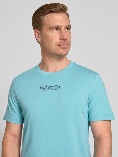 Mężczyzna model nosi Regular Fit T-Shirt aus reiner Baumwolle von s.Oliver RED LABEL, kolor jednolity, okrągły dekolt, krótki rękaw, jersey, nadruk z logo, widok pełnopostaciowy z przodu.