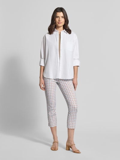 Frauenmodel trägt Caprihose mit Stretch-Anteil in verkürzter Passform von SEDUCTIVE mit Muster, Elastischer Material-Mix, Bundfalten, Ganzkörperansicht von vorne.