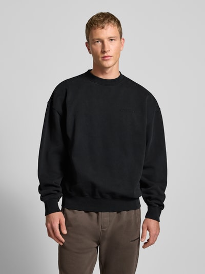Mannermodel draagt Oversized sweatshirt met labelstitching van Pegador in zwart, katoenmix, ribboorden, ronde hals, Ganzkörperansicht van voren.