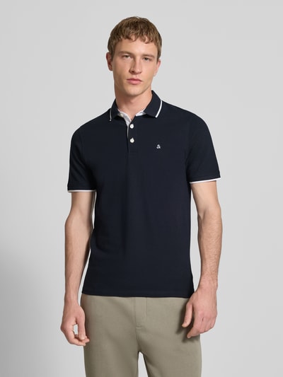 Männermodel trägt Slim Fit Poloshirt mit Viskose-Anteil Modell 'Paulos' von JACK & JONES, dunkle Farbe, Baumwoll-Mix, Logo-Stitching, Rückenlänge 72 cm bei Größe M, Ganzkörperansicht von vorne.