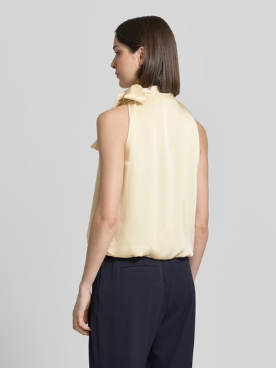 Frauenmodel trägt Blusentop mit Schluppe Modell 'Veda' von Neo Noir aus cremefarbenem Satin, gerader Schnitt, Ballonsaum, Ganzkörperansicht Rückansicht.
