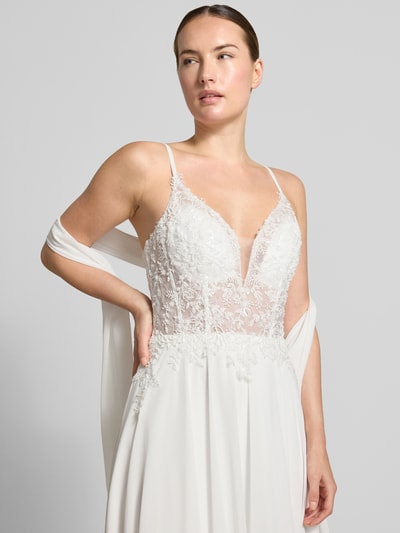 Modelka nosi Brautkleid mit Ziersteinbesatz od Mascara w kolorze białym, kwiatowy wzór, krój taliowany, dekolt w serek, cienkie ramiączka, Szerokość w rozmiarze 36: 34 cm, Długość tyłu w rozmiarze 36: 143 cm, zbliżenie górnej części ciała.