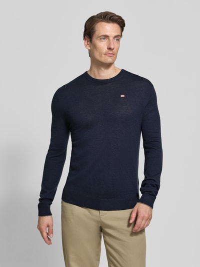 Männermodel trägt sweter wełniany z czystej wełny, krój slim fit, Model 'DAMAVAND' od Napapijri, detal z logo, elastyczne wykończenia, ciemnogranatowy, Długość tyłu w rozmiarze M: 66 cm, Długość rękawów w rozmiarze M: 69 cm, Ganzkörperansicht von vorne