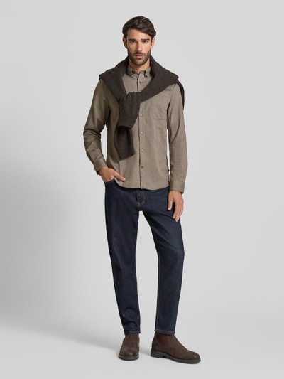 Męski model nosi Koszulę casualową z mieszanki bawełny, krój regular fit, model 'trostol' od Matinique, kołnierzyk typu button down, listwa guzikowa, brustasza, długość tyłu w rozmiarze M 78 cm, szerokość ramion w rozmiarze M 44 cm, długość rękawów w rozmiarze M 66 cm, odcienie brązu i beżu, gładka tekstura, widok całej sylwetki z przodu.