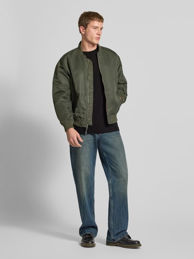 Męski model nosi Regular Fit T-shirt mit Logo-Print Modell 'True' von G-Star Raw, czarny, okrągły dekolt, długość tyłu w rozmiarze M: 66 cm, ganzkörperansicht von vorne