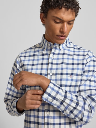 Männermodel trägt Freizeithemd mit Knopfleiste von Gant aus reiner Baumwolle im Regular-Fit, kariert, mit Button-Down-Kragen, Brusttasche und Label-Stitching, Nahaufnahme Oberkörper.