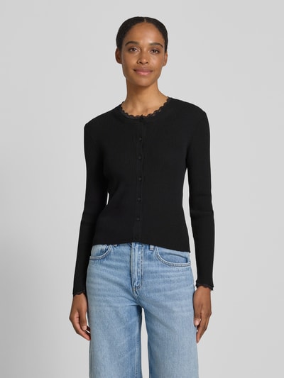 Frauenmodel trägt Slim Fit Strickjacke aus Viskose-Mix Modell 'Wonder' von Vero Moda, Optik: Unifarben, Spitzen-Besatz, Rundhals, Langarm, Rippstrick; Ganzkörperansicht von vorne.