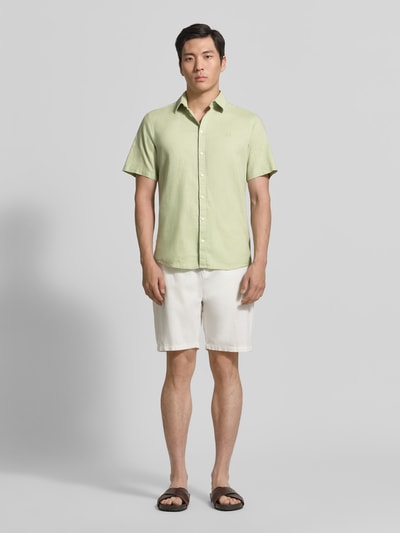 Männermodel trägt Slim Fit Freizeithemd aus Leinen-Baumwoll-Mix Modell 'AKSEL' von Casual Friday in Hellgrün, Ganzkörperansicht von vorne, Knopfleiste, Label-Stitching, Kentkragen, Rückenlänge 78 cm, Schulterbreite 45 cm, Ärmellänge 27 cm.