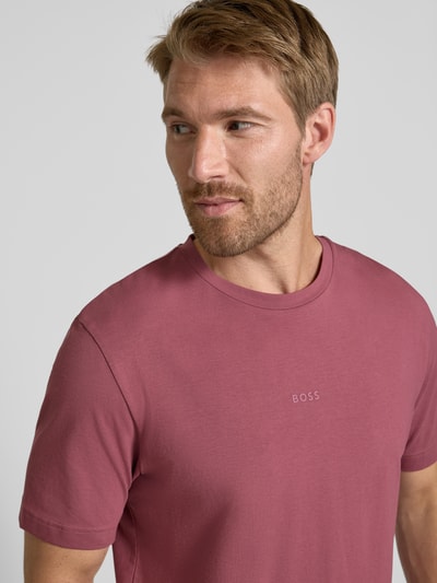 Männermodel trägt Relaxed Fit T-Shirt aus reiner Baumwolle Modell 'TCHUP' von BOSS Orange in Altrosa, glatte Oberfläche, Nahaufnahme Oberkörper.