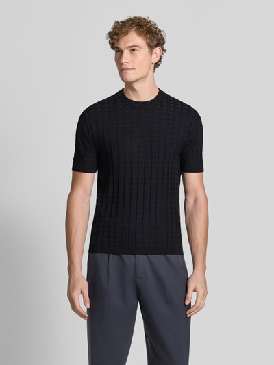 Männermodel trägt Strickshirt aus Viskose-Mix mit Strukturmuster von Armani Exchange in Schwarz, Slim Fit, Rundhalsausschnitt, Ganzkörperansicht von vorne.