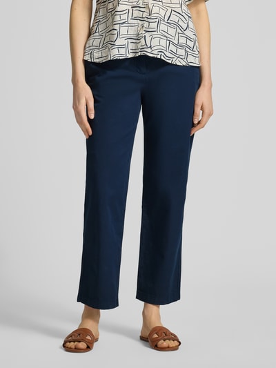 Kobieta nosi Slim Fit Chino aus Baumwoll-Mix od Tommy Hilfiger, efekt: jednolity kolor, krój slim fit, mieszanka bawełny, wpuszczane kieszenie, szlufki na pasek, zapięcie na guzik i zamek błyskawiczny, widok na całe ciało z przodu.