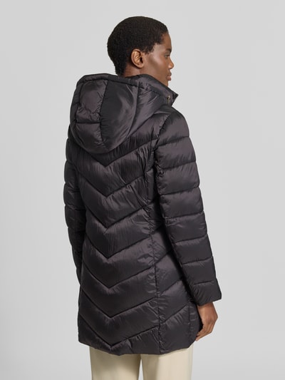 Vrouwenmodel draagt Steppmantel met Kapuze und Reißverschlusstaschen van MICHAEL Michael Kors in zwart met doorgestikte naden, recht model, capuchon met tunnelkoord, opstaande kraag, ritssluiting, zij-ritszakken, ruglengte maat S 86 cm, schouderbreedte 43 cm, borstwijdte 50 cm, mouwlengte 62 cm, Ganzkörperansicht Rückansicht.