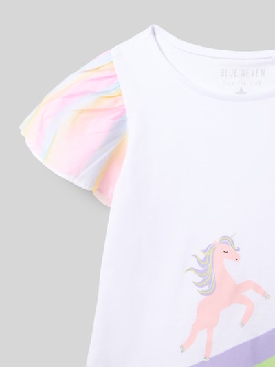Mädchen trägt T-Shirt mit Rundhalsausschnitt und Motiv-Print von Blue Seven, reine Baumwolle, Schmetterlingsärmel mit Chiffon, Nahaufnahme Oberkörper.