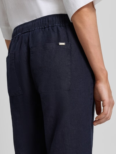 Vrouwenmodel draagt Wide Leg Caprihose aus Leinen Modell 'PIA' van TONI in donkerblauw, zuiver linnen, elastische band met tunnelkoord, maat 36, binnenbeenlengte 58 cm, detailopname achterzijde.