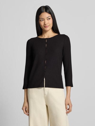 Frauenmodel trägt Strickjacke aus Baumwoll-Mix Modell 'Kariane' von someday, schmale Passform, Knopfleiste, Nahaufnahme Oberkörper.