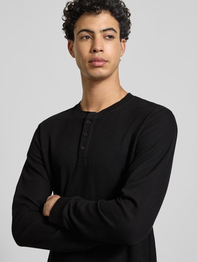 Männermodel trägt Regular Fit Longsleeve in Strick-Optik Modell 'Niagara' von JACK & JONES, Baumwoll-Mix, Henley-Ausschnitt, Nahaufnahme Oberkörper.