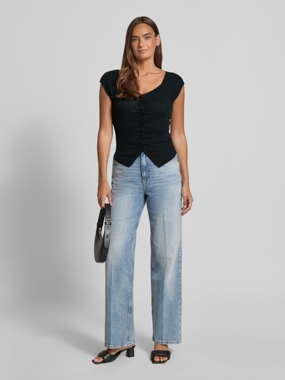 Frauenmodel trägt Strickshirt mit Knopfleiste und Raffungen von JAKE*S STUDIO WOMAN, schwarz, körpernah, V-Ausschnitt, Ganzkörperansicht von vorne.