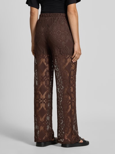 Vrouwenmodel draagt Stoffen broek van Kant Model 'ALMI' van YAS, Materiaalmix met katoen, regular fit, elastische band, ondoorzichtige ondershorts, bandwijdte maat 36: 35 cm, binnenbeenlengte maat 36: 75 cm, volledig bruin met kantmotief, volledige rugaanzicht.