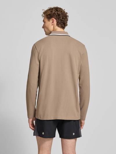 Männermodel trägt Regular Fit Poloshirt aus reiner Baumwolle Modell 'Plisy' von BOSS, sandfarben, feine Struktur, Ganzkörperansicht Rückansicht, Herren Poloshirt von BOSS Green.