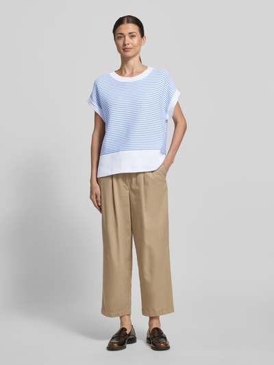 Frauenmodel trägt T-Shirt aus reiner Baumwolle in Strick-Optik Modell 'Kipe' von JOOP!, lockere Passform, überwiegend hellblau und weiß gestreift, mit Rundhalsausschnitt und Label-Detail; Ganzkörperansicht von vorne.