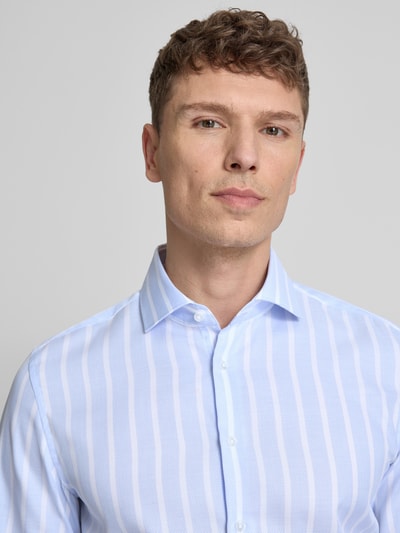 Männermodel trägt Slim Fit Business-Hemd aus katoen met kentkraag van SEIDENSTICKER, lichtblauw met witte strepen, knoopsluiting, puur katoen, slim fit, kentkraag, ruglengte maat 40: 77 cm, schouderbreedte: 40 cm, mouwlengte: 66 cm, nahaufnahme oberkörper.