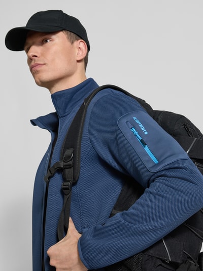 Männermodel trägt Regular Fit Jacke mit Stehkragen Modell 'BREDSTEDT' von Icepeak in Blau, sichtbare Reißverschlusstaschen, Nahaufnahme Oberkörper. Kontext: Herren Jacke von Icepeak, Regular Fit, Arm- und Eingrifftaschen mit Reißverschluss, elastische Abschlüsse, Maße bei Größe M.