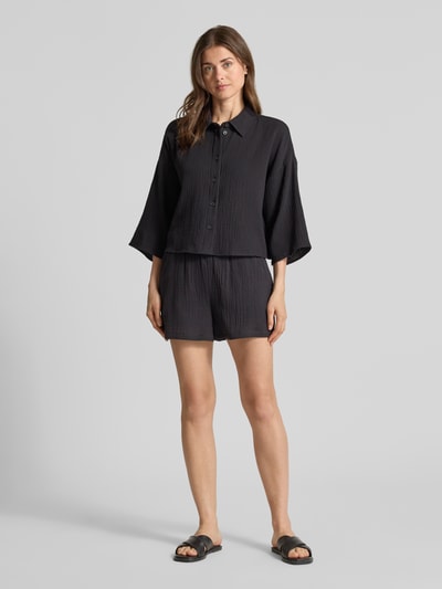 Frauenmodel trägt Loose Fit Shorts aus reiner Baumwolle Modell 'NATALI' von Vero Moda, Optik: Unifarben, Crêpe Textur, Ganzkörperansicht von vorne.