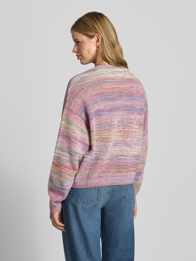 Frauenmodel trägt Strickpullover mit überschnittenen Schultern Modell 'Keenan' von Carhartt Work In Progress in Pastellfarben, Reine Baumwolle, Lockerer-Schnitt, Rundhalsausschnitt, Rückenlänge bei Größe S 54 cm, Ärmellänge 52 cm, Ganzkörperansicht Rückansicht.