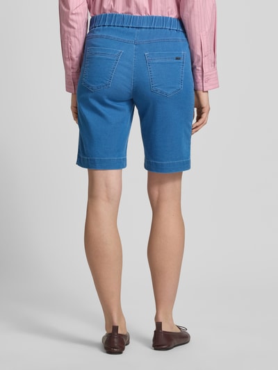 Frauenmodel trägt Straight Fit Shorts mit Gesäßtaschen Modell 'Sue' von TONI aus Elastischer-Baumwoll-Mix in Blau, Ganzkörperansicht Rückansicht.