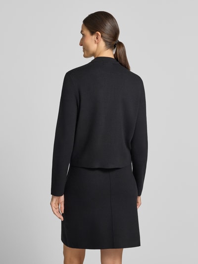 Modelka nosi Regular Fit kardigan rozpinany z czystej wiskozy 'Regular Fit Strickjacke aus reiner Viskose' od Christian Berg Woman, luźny krój, wykładany kołnierz, zamek błyskawiczny dwustronny, nakładane kieszenie na piersi, czarny kolor, gładka faktura, Długość tyłu w rozmiarze S: 53 cm, Długość rękawów w rozmiarze S: 61 cm, widok całej sylwetki z tyłu.