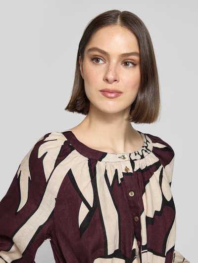 Frauenmodel trägt Midikleid aus reinen Leinen mit floralem Allover-Print von Christian Berg Woman in Beige und Dunkellila, Knopfleiste, Rundhalsausschnitt, 3/4-Arm, taillierte Passform, Nahaufnahme Oberkörper.