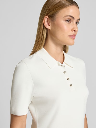 Vrouwenmodel draagt T-shirt uit viscosemix met stretch, nauwsluitend model, model 'ELBETH' van Ted Baker, polokraag, knoopsluiting, dames, detailopname bovenlichaam. Context: dames T-shirt, ruglengte maat 36: 58 cm.
