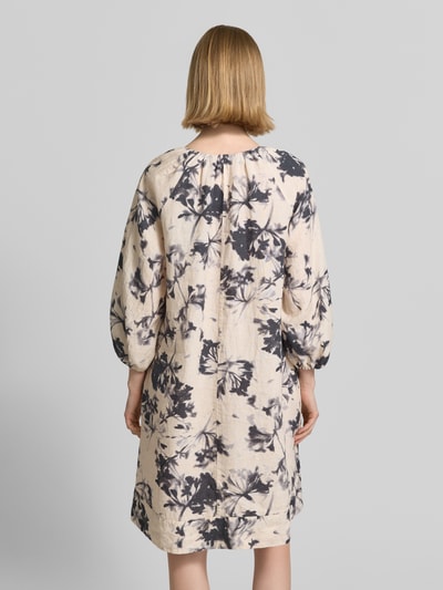 Frauenmodel trägt Fließendes Tunikakleid aus reinem Leinen von Marc O'Polo, Optik:Allover-Muster, Passform fließend, Midi-Länge, Materialverarbeitung Flammgarn, florales Muster in Grau auf hellem Grund, Ärmelabschluss elastisch, Ganzkörperansicht Rückansicht.